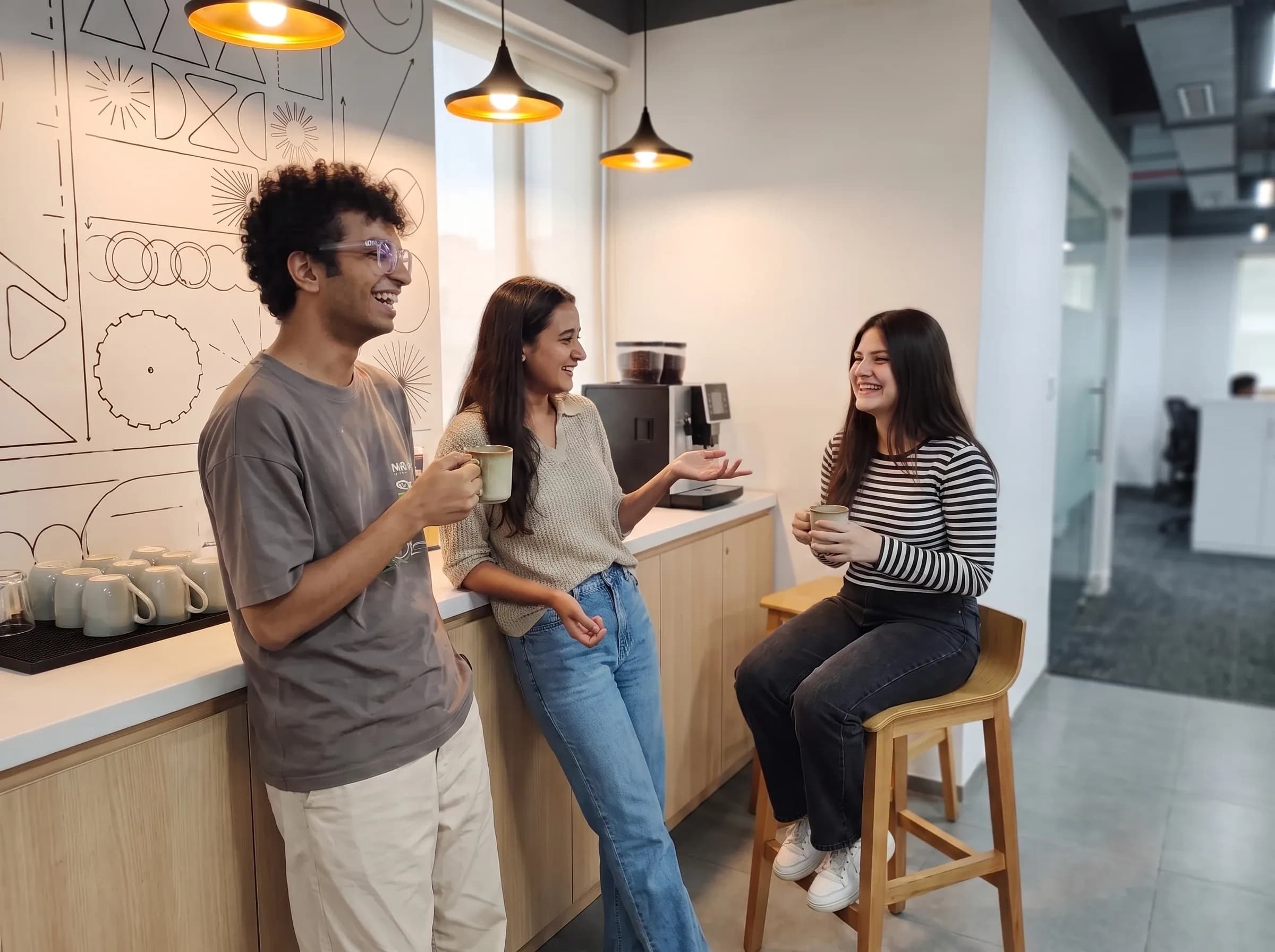 DigiIQ team members sharing a laugh over coffee in the office cafeteria
