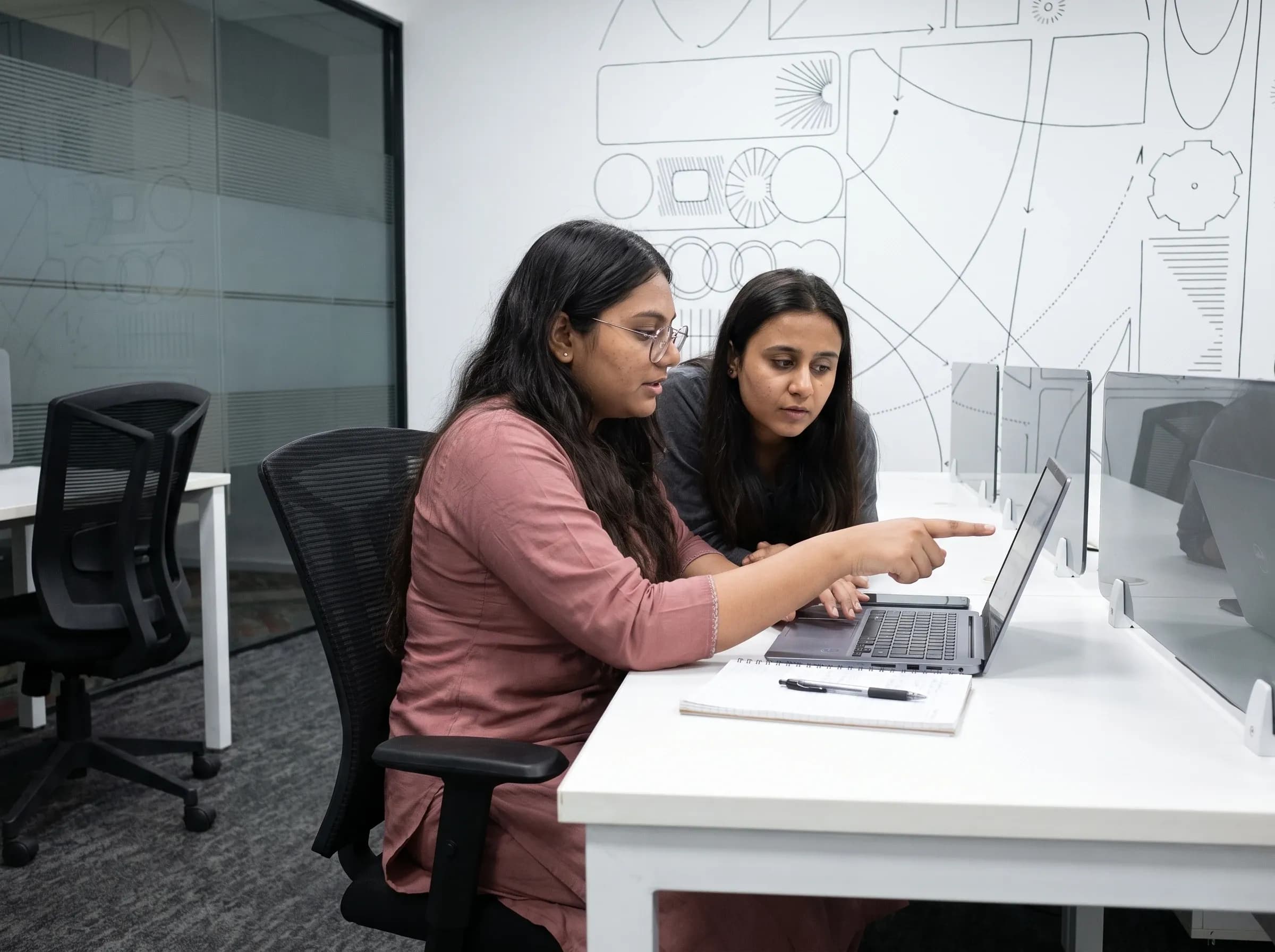 Two DigiIQ engineers working through a problem together at a laptop