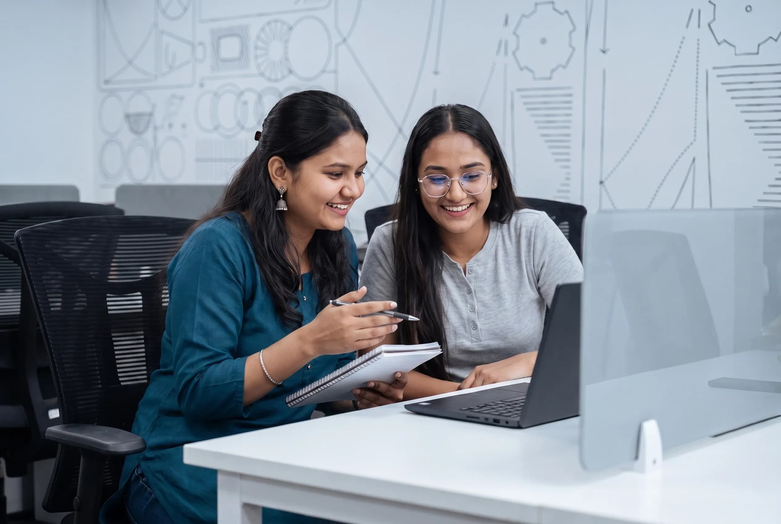 Two DigiIQ team members reviewing work together at a laptop